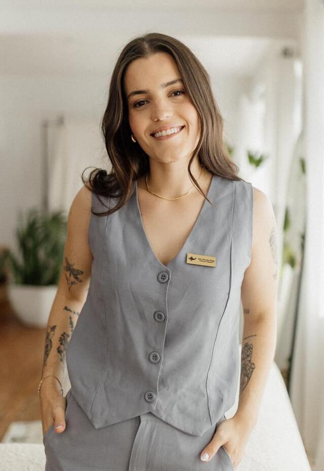 Enfermeira Giovana Braga sorrindo, vestindo colete cinza